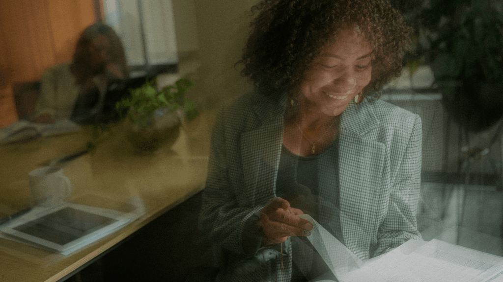Smiling woman in checkered blazer looking at a document